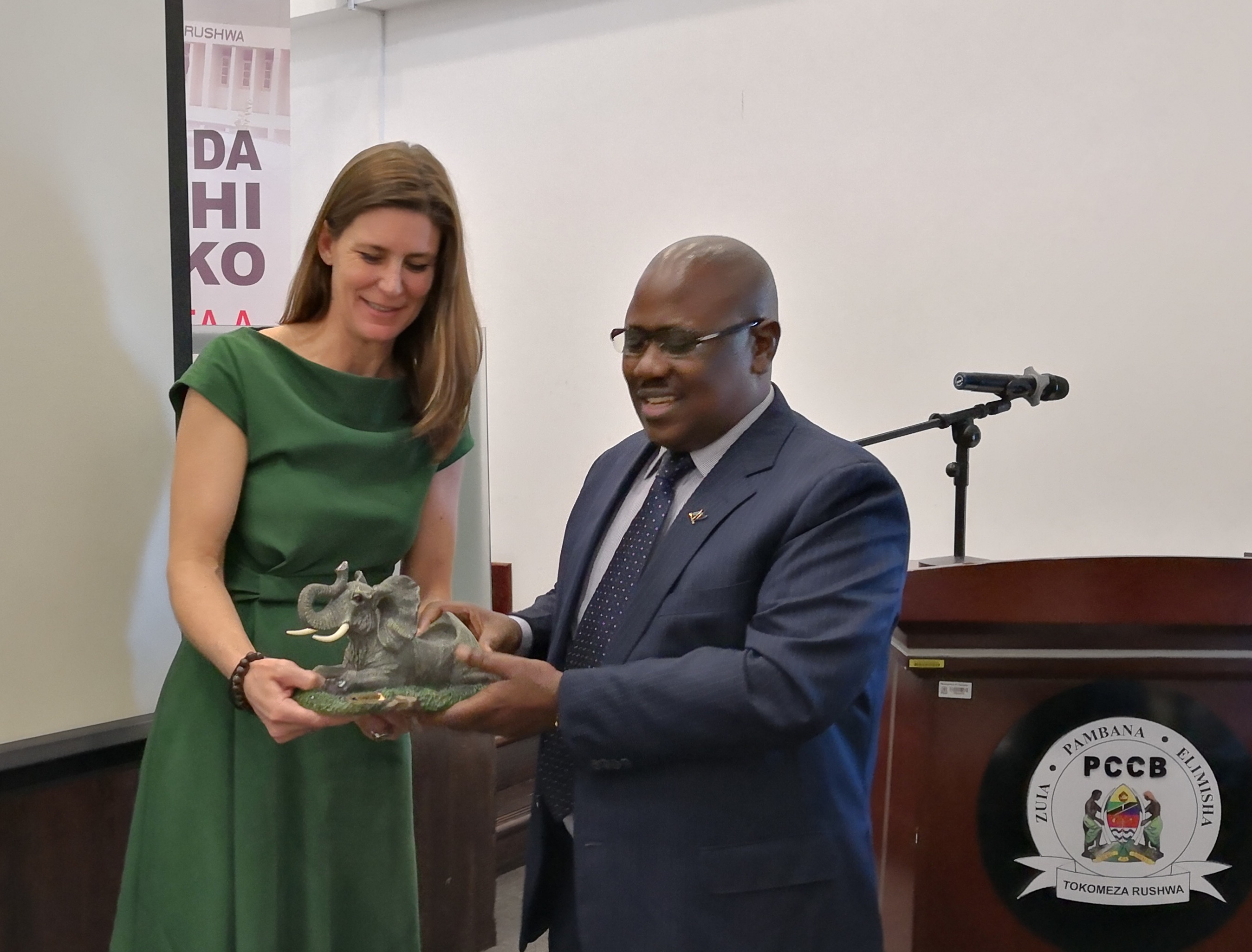 Gretta Fenner receives elephant sculpture from the Tanzanian PCCB