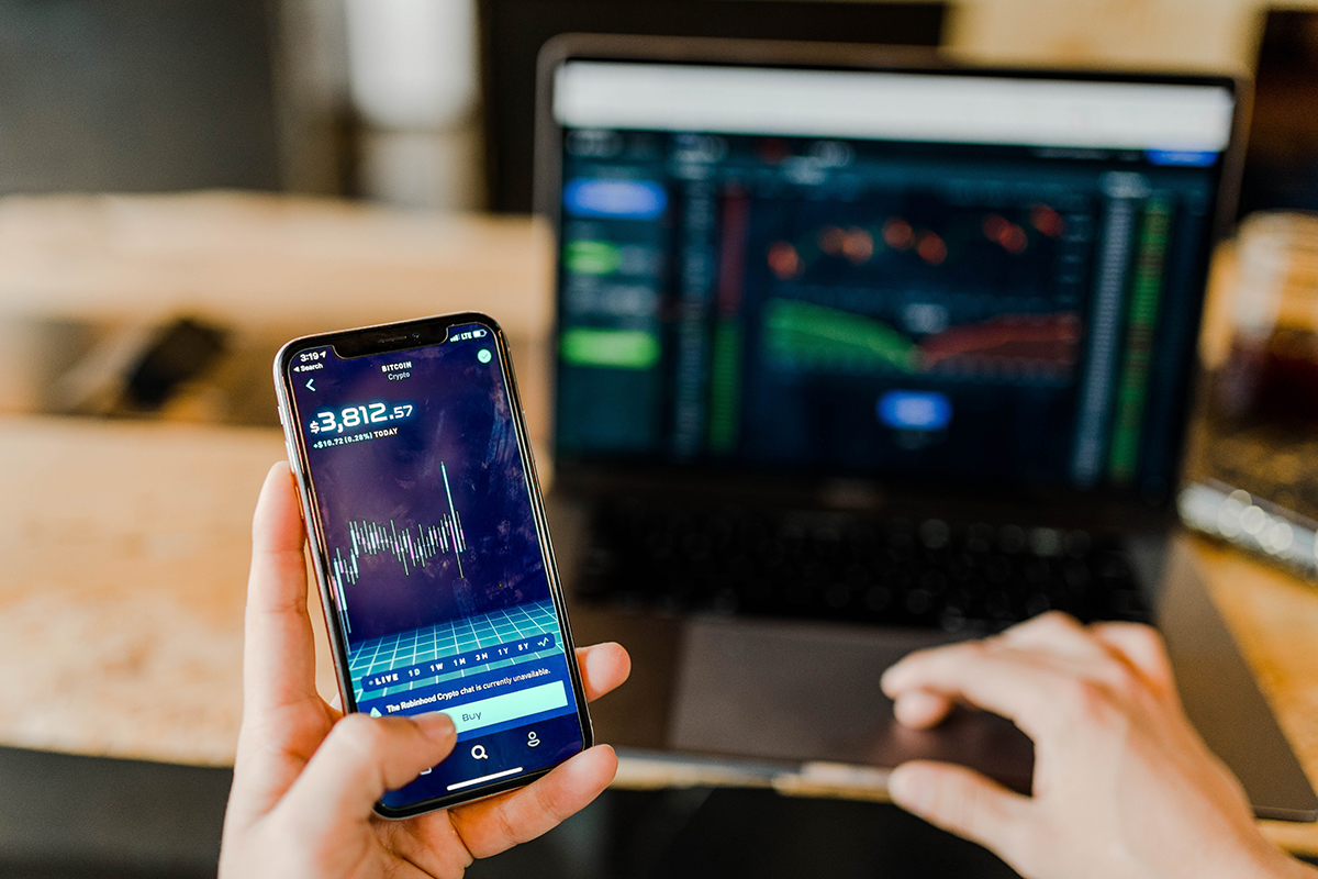 Cryptocurrency on mobile phone and laptop. Photo by Austin Distel on Unsplash, www.distel.com