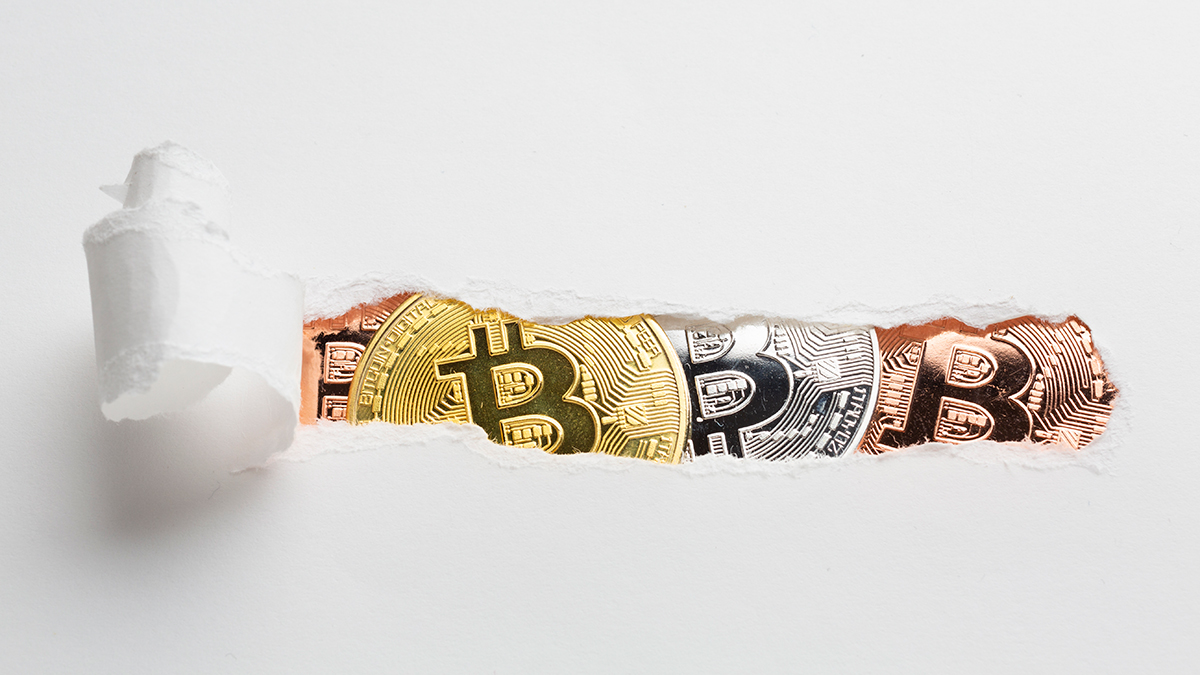 Ripped paper revealing bitcoin